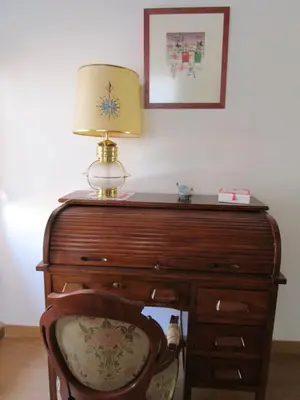 a lamp on top of a wooden desk with a chair at Ca'ls avis in Serra
