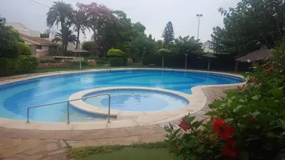 a large blue swimming pool in a yard at Urbanización Cullera Park - Carmen y Jose in Cullera