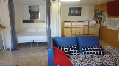 a room with a couch and a bed and a mirror at Urbanización Cullera Park - Carmen y Jose in Cullera