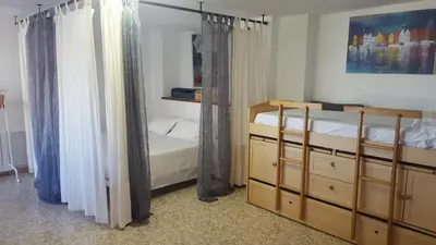 a bedroom with two bunk beds and curtains at Urbanización Cullera Park - Carmen y Jose in Cullera
