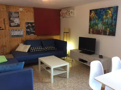 a living room with a blue couch and a tv at Urbanización Cullera Park - Carmen y Jose in Cullera