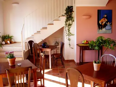 a dining room with a table and chairs and a staircase at Sharíqua in Jérica