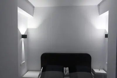 a bedroom with a black bed and two windows at 5 SENSES in Valencia