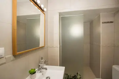 a bathroom with a sink and a mirror and a shower at SingularStays Quevedo in Valencia