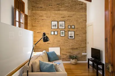 a living room with a couch and a brick wall at SingularStays Quevedo in Valencia