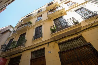 a tall yellow building with balconies and windows at SingularStays Quevedo in Valencia