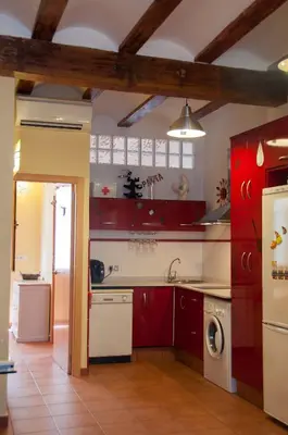 a kitchen with red cabinets and a white dishwasher at Homely Nest Valencia El Carme in Valencia