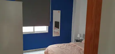 a blue bedroom with a bed and a window at Apartamento Ciudad de las Ciencias 3 in Valencia