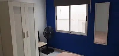 a blue room with a fan and a window at Apartamento Ciudad de las Ciencias 3 in Valencia