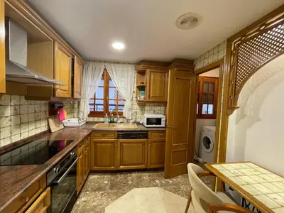 a kitchen with wooden cabinets and a sink at Varone in Requena