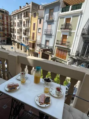 a table with plates of food and drinks on a balcony at Varone in Requena