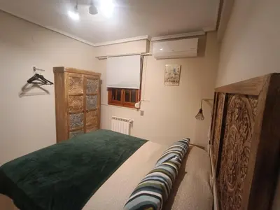 a bedroom with a bed with a green blanket at Varone in Requena