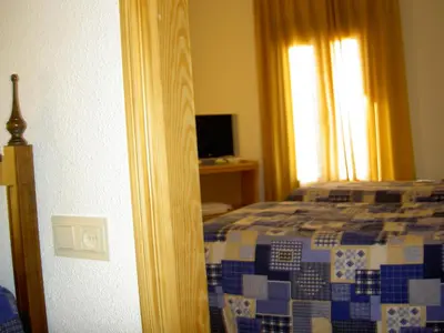 a bedroom with a bed and a window at Hotel Álvarez in Tuéjar