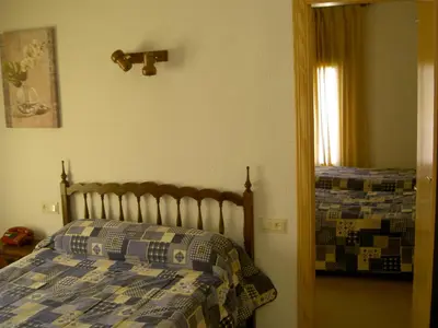 a bedroom with a bed with a quilt on it at Hotel Álvarez in Tuéjar