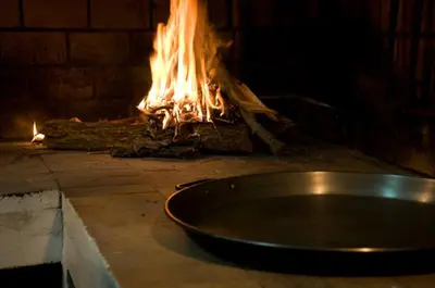 a metal pan sitting in front of a fire at Hotel Álvarez in Tuéjar