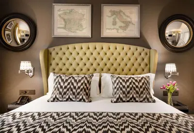 a bedroom with a large bed and two mirrors at NH Collection Colón Valencia in Valencia