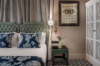 a bedroom with a bed with blue and white pillows at NH Collection Colón Valencia in Valencia