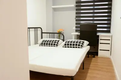 a bedroom with a bed and a desk and a window at Piso en La Ciudad de Artes in Valencia