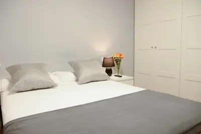 a bedroom with a white bed with a vase of flowers at Piso en La Ciudad de Artes in Valencia