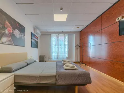 a bedroom with a bed and a large wooden wall at Suites Rooms Valencia in Valencia