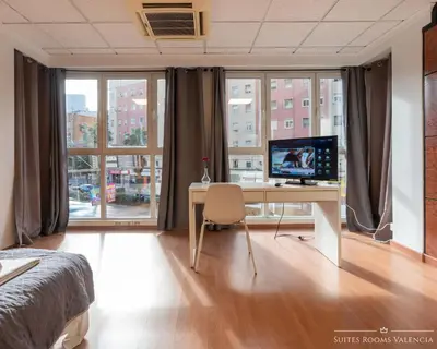 a bedroom with a desk with a computer on it at Suites Rooms Valencia in Valencia