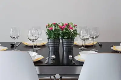 a table with plates and wine glasses and flowers at Your home at Valencia, Cabañal in Valencia
