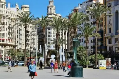 a group of people walking around a city with palm trees at Your home at Valencia, Cabañal in Valencia