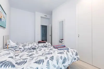 two beds in a bedroom with white walls at Luxury Beach Front Apartment with Pool in Valencia