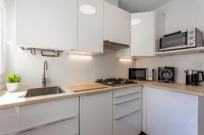 a kitchen with white cabinets and a sink and a microwave at Valencia Flat Rental Malvarrosa Beach zone in Valencia