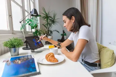 a woman sitting at a desk with a plate of food at SingularStays Ms Rogers in Valencia