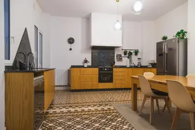 a kitchen with a wooden table and a refrigerator at SingularStays Ms Rogers in Valencia