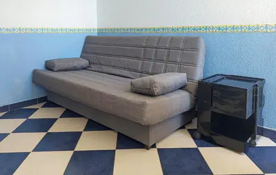 a brown couch sitting in a room with a television at One-Bedroom Apartment In La Pobla De Farnals in Puebla de Farnals