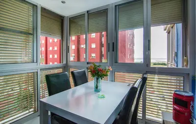 a dining room with a table and chairs and windows at One-Bedroom Apartment In La Pobla De Farnals in Puebla de Farnals