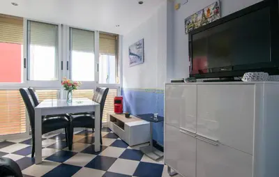 a living room with a table and a flat screen tv at One-Bedroom Apartment In La Pobla De Farnals in Puebla de Farnals