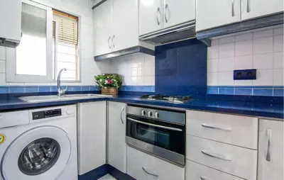a kitchen with a washing machine and a sink at One-Bedroom Apartment In La Pobla De Farnals in Puebla de Farnals