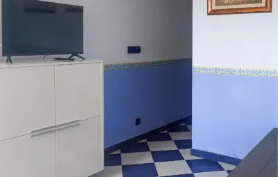 a room with a tv and a blue and white floor at One-Bedroom Apartment In La Pobla De Farnals in Puebla de Farnals