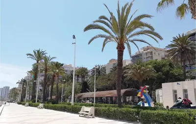 a street with palm trees and a building at 1 Bedroom Nice Apartment In Cullera in Cullera