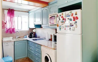 a kitchen with blue cabinets and a white refrigerator at 1 Bedroom Nice Apartment In Cullera in Cullera