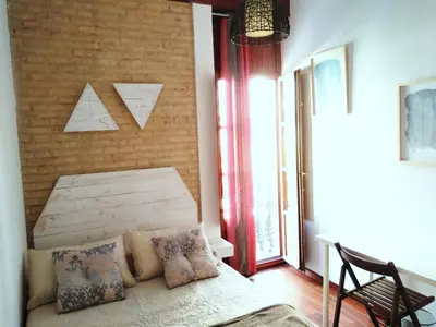 a bedroom with a bed and a brick wall at Ruzafa, centro ciudad. Terraza-wifi in Valencia