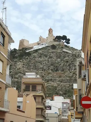 a castle on top of a hill with buildings at Apartamento Justina in Cullera