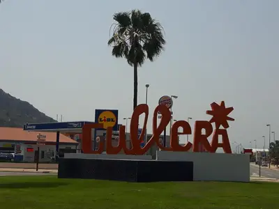 a sign for a gas station with a palm tree at Apartamento Justina in Cullera
