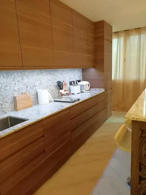 a kitchen with wooden cabinets and a sink at el piso perfecto in Puerto de Sagunto