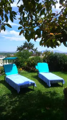 two beds sitting in the grass under a tree at Casa Rural La Torreta in Corbera de Alcira