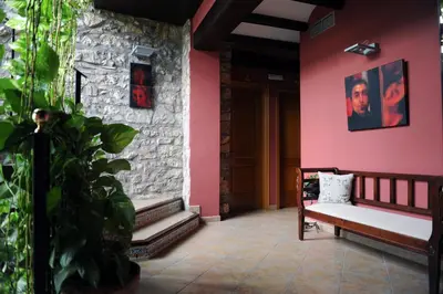 a porch with a bench and a pink wall at Hotel Restaurant Verdià in Sueras