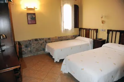 a room with two beds and a window at Hotel Restaurant Verdià in Sueras