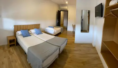 a bedroom with a large bed and a couch at Nanit Valencia Hostel in Valencia