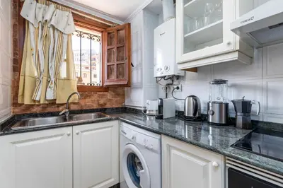a kitchen with a sink and a washing machine at Beach Apartment with beautiful view in Port Saplaya