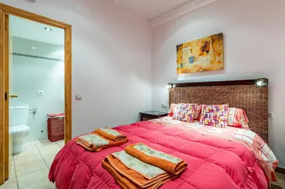 a bedroom with a red bed with towels on it at Beach Apartment with beautiful view in Port Saplaya