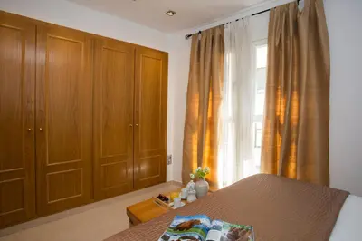 a bedroom with wooden cabinets and a bed and a window at SingularStays Poeta Querol in Valencia