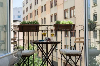 a balcony with a table with glasses and plants on it at SingularStays Poeta Querol in Valencia
